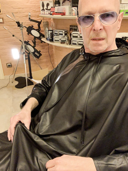 Lenny52, seduto nudo sulla poltrona di pelle nera della sua scrivania, ha indossato l'abito sintetico del parrucchiere.